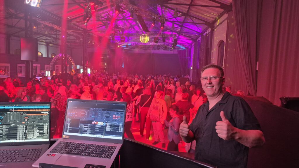 Tanzende Menschenmeng mit DJ und Laptop auf einer Bühne. Dein Hochzeits- und Event DJ für Wismar und MV