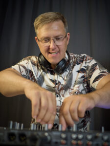 Scherni als DJ beim Mixen von Musik