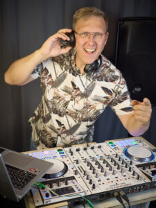 DJ-Scherni am Mischpult mit Kopfhörer